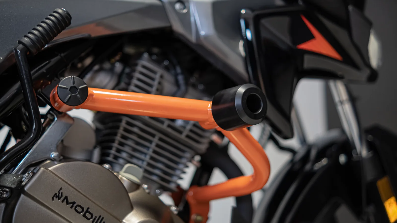 Protetor de motor laranja instalado na moto Virtoo